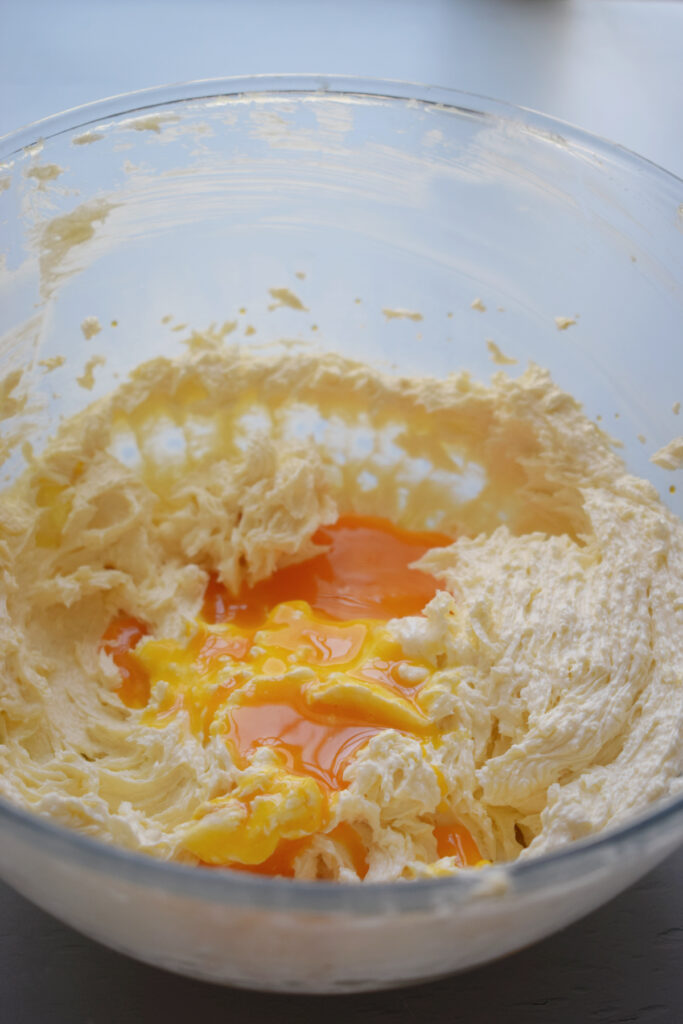 Egg yolks in a bowl with butter and sugar.
