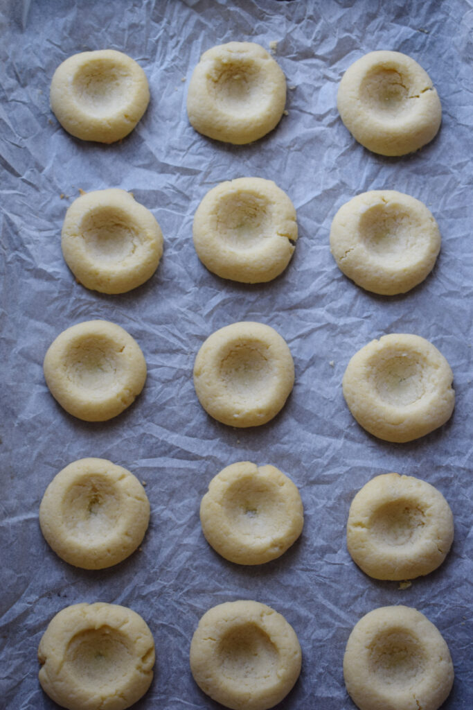 Baked thumbprint cookies on a baking tray.