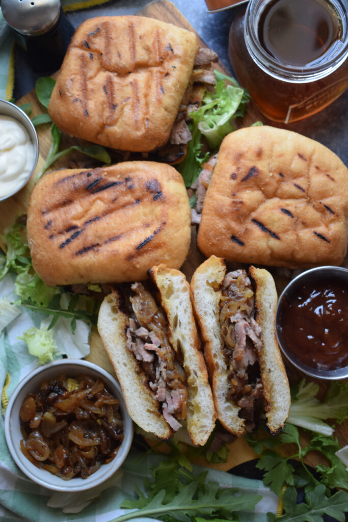 Steak sandwiches with barbecue sauce and salad leaves.
