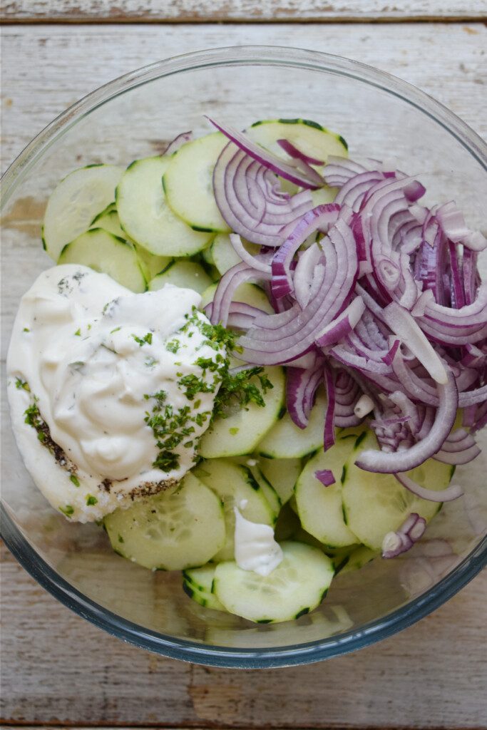 Ingredients in a bowl to make a cucumber salad.