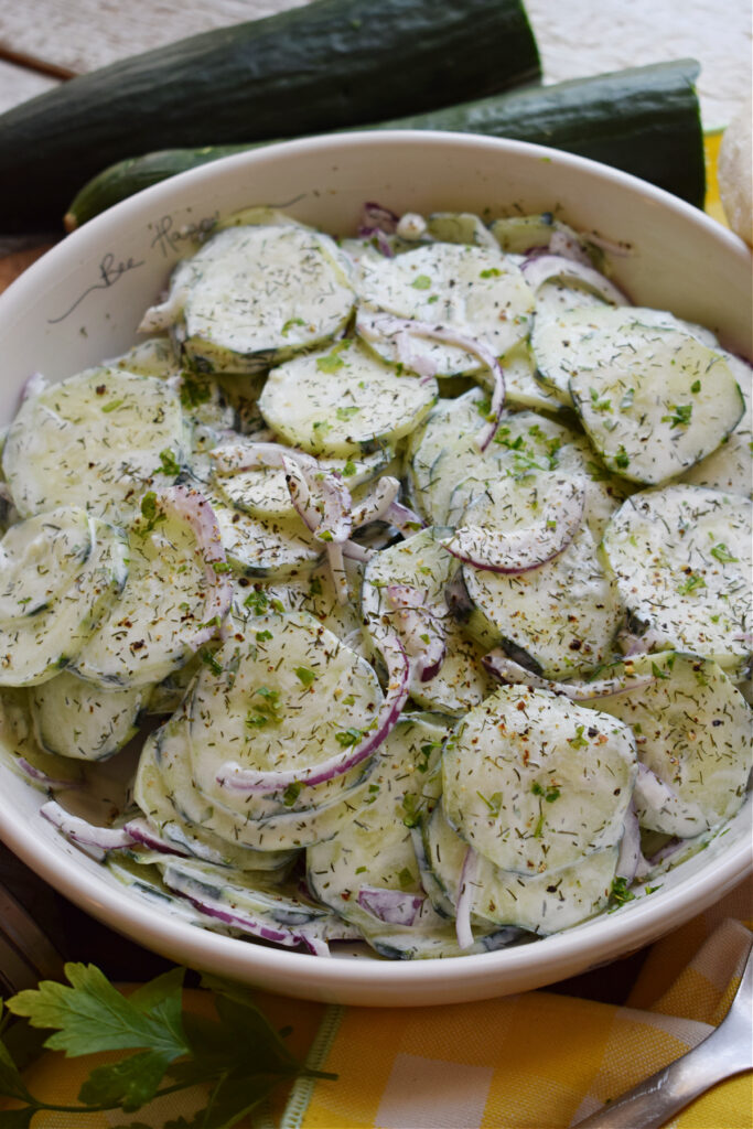 Cucumber salad in a bowl with red onions and dill.