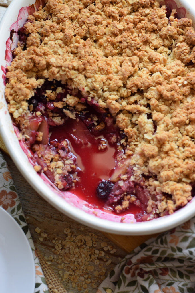 Apple crisp with berries in a serving dish.