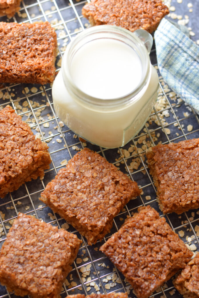 Flapjacks on a baking rack with a glass of milk.