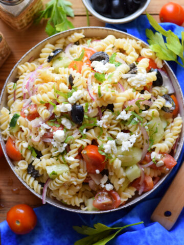 Pasta salad in a bowl with chopped vegetables.
