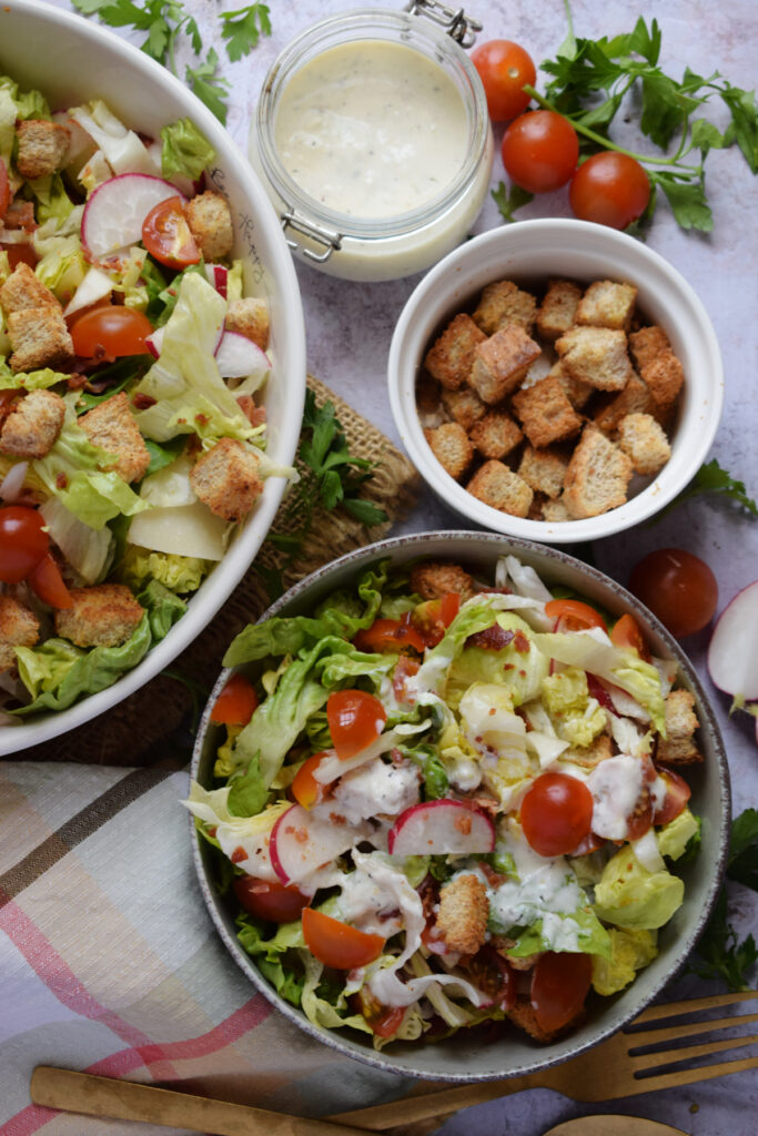 Salad in bowls with croutons and dressing.