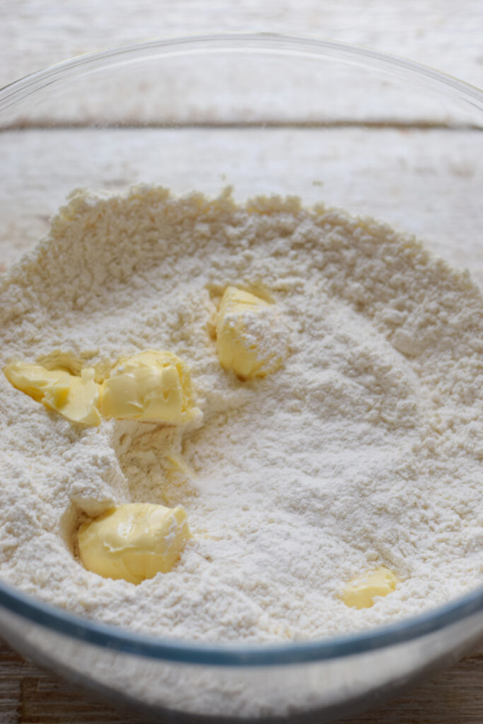 Add cold butter to dry ingredients in a glass bowl.