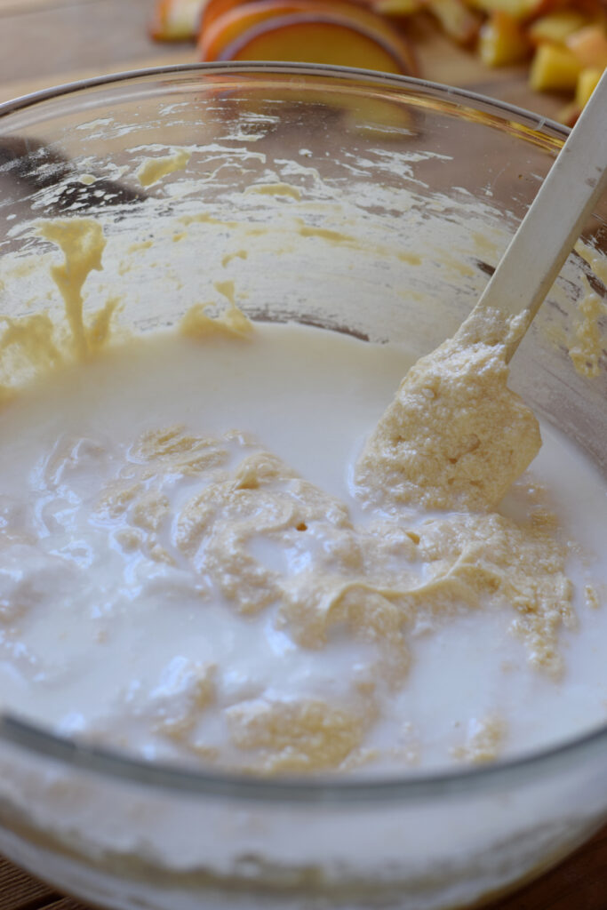 Adding milk to cake batter.