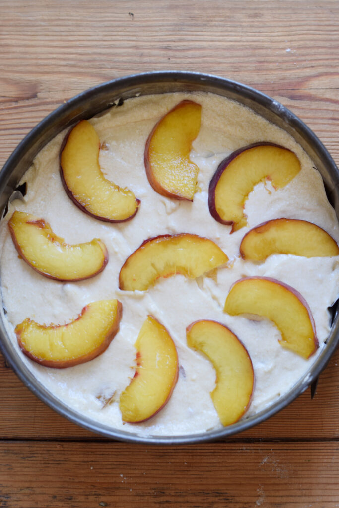 Cake topped with peach slices.