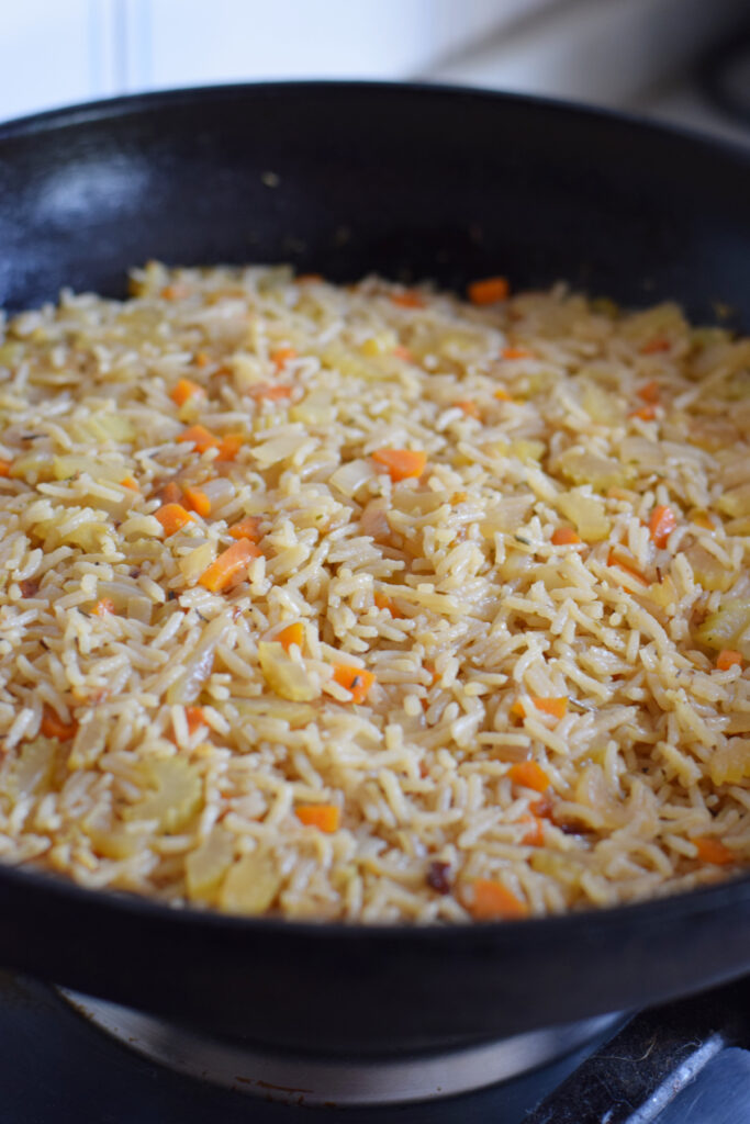 Cooked rice and vegetables in a skillet.