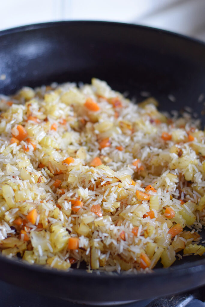 Cooking rice and vegetables in a skillet.