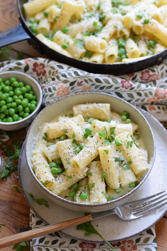 Rigatoni with pasta and peas in a bowl.