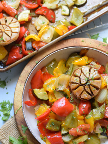 Sheet pan vegetables in a bowl and on a tray.