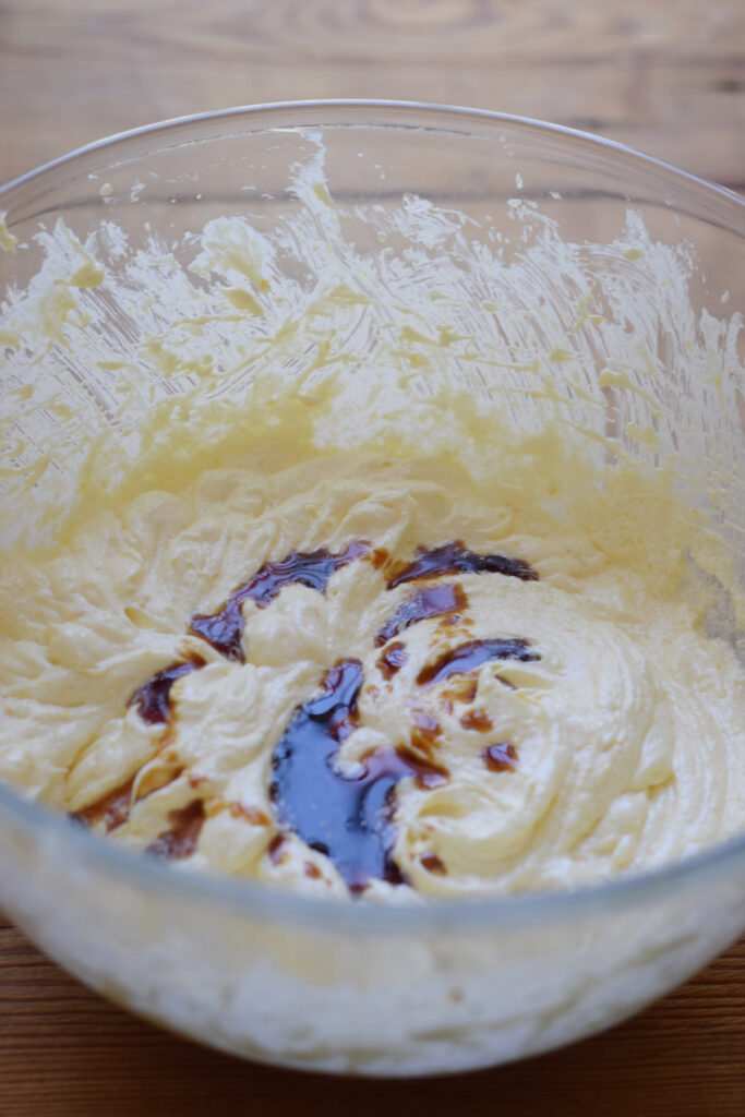 Adding vanilla extract to cake batter.
