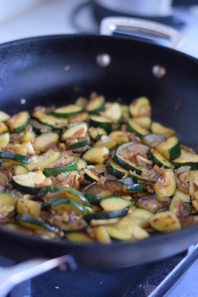 Cooked zucchini and celery in a skillet.