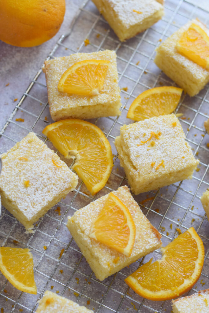 Orange cake squares on a baking tray.