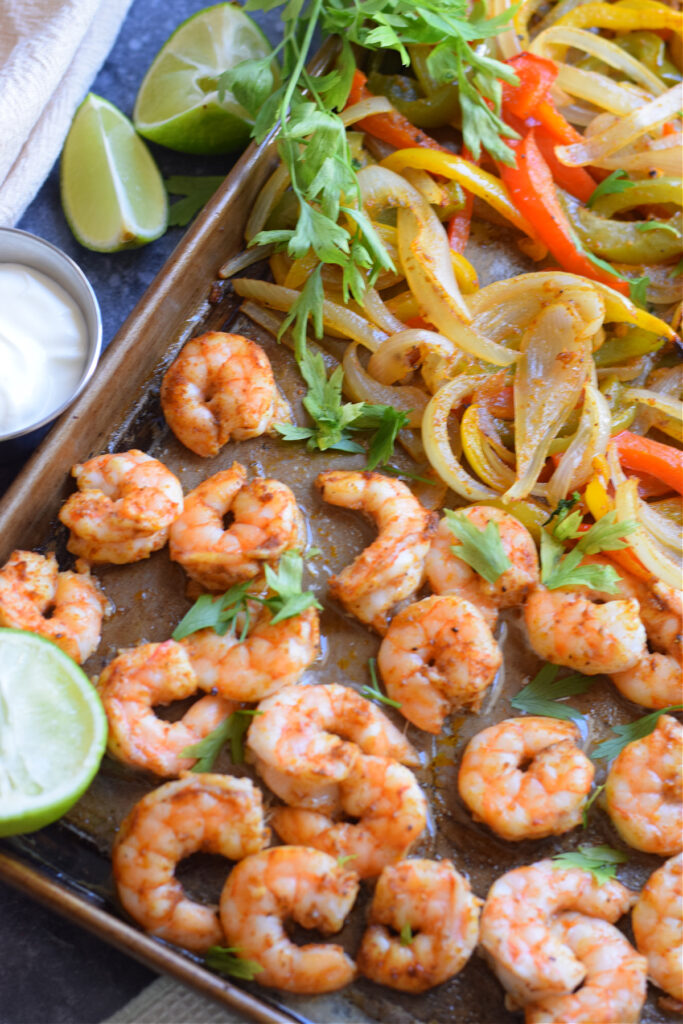 Baked shrimp and peppers on a baking tray.