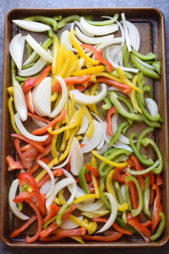 Peppers and onions on a baking tray.