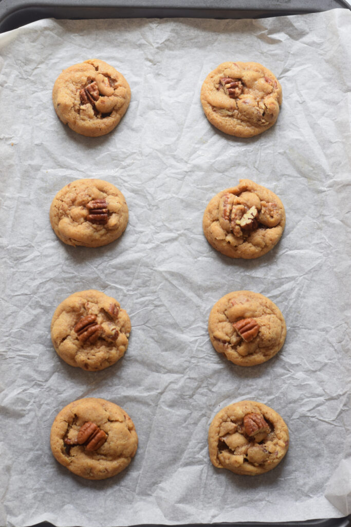 Baked pecan cookies on a baking tray.
