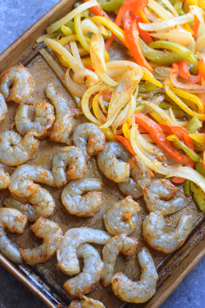 Raw shrimp on a tray with peppers.
