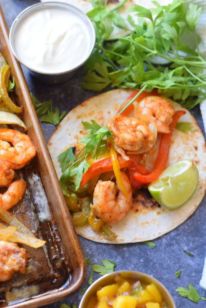 Shrimp and peppers on a flour tortilla wrap.