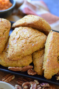 Close up of pumpkin scones on a black plate.