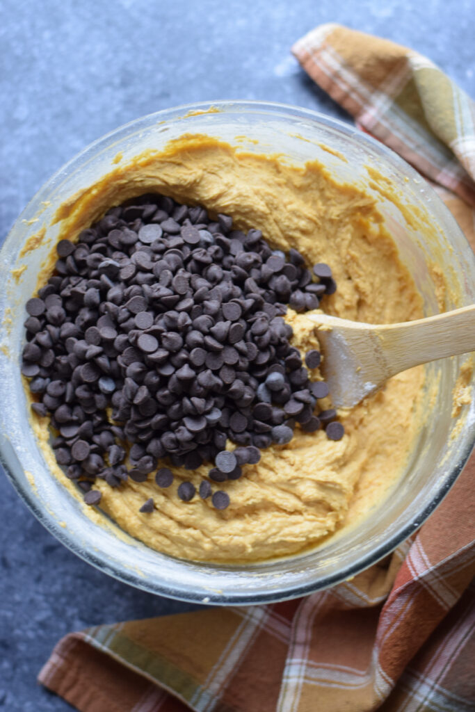 Adding chocolate chips to cookie dough.