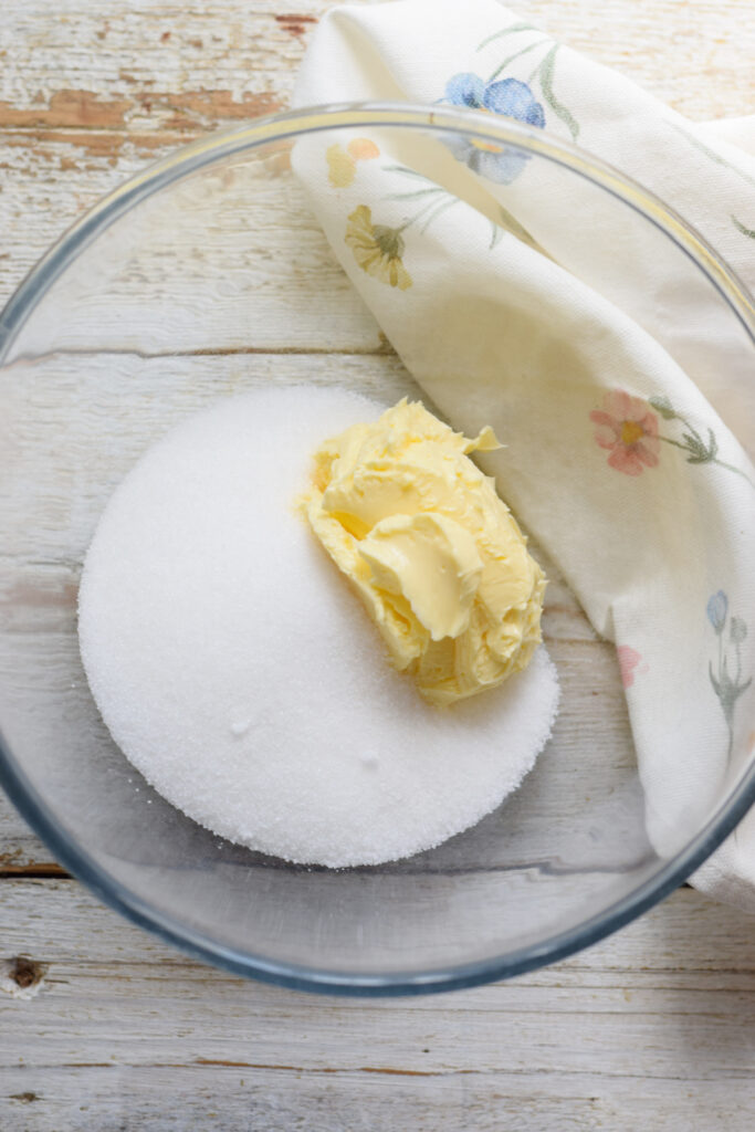 Butter and sugar in a glass bowl.