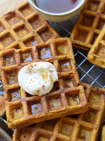 Close up of pumpkin waffles with whipped cream.