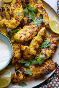Spiced chicken tenders with yogurt sauce on the side.
