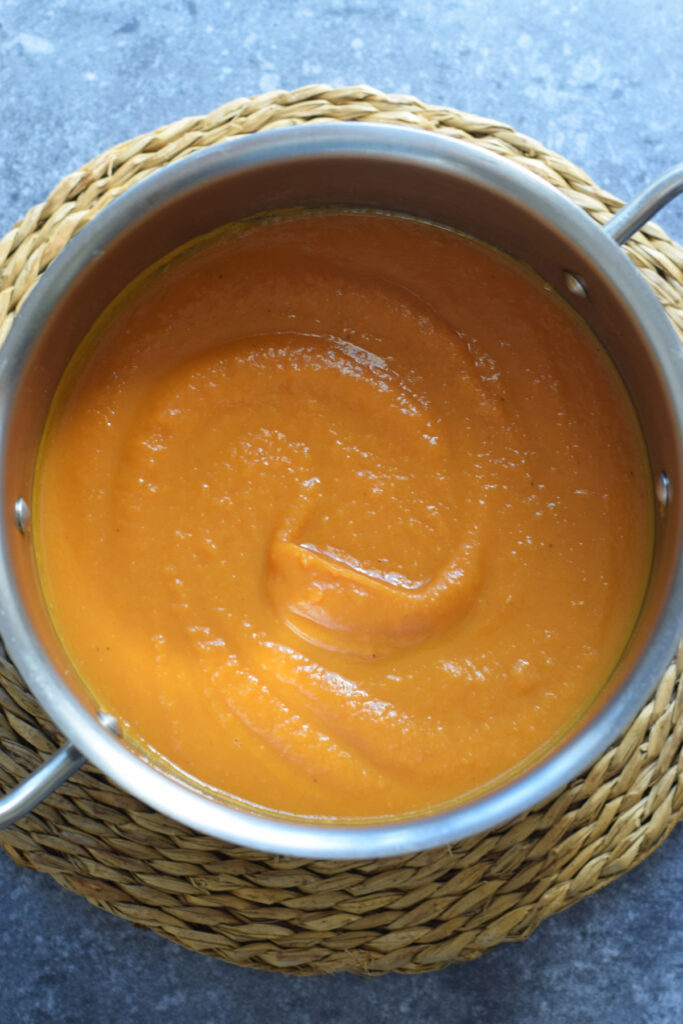Smooth roasted sweet potato soup in a pot.