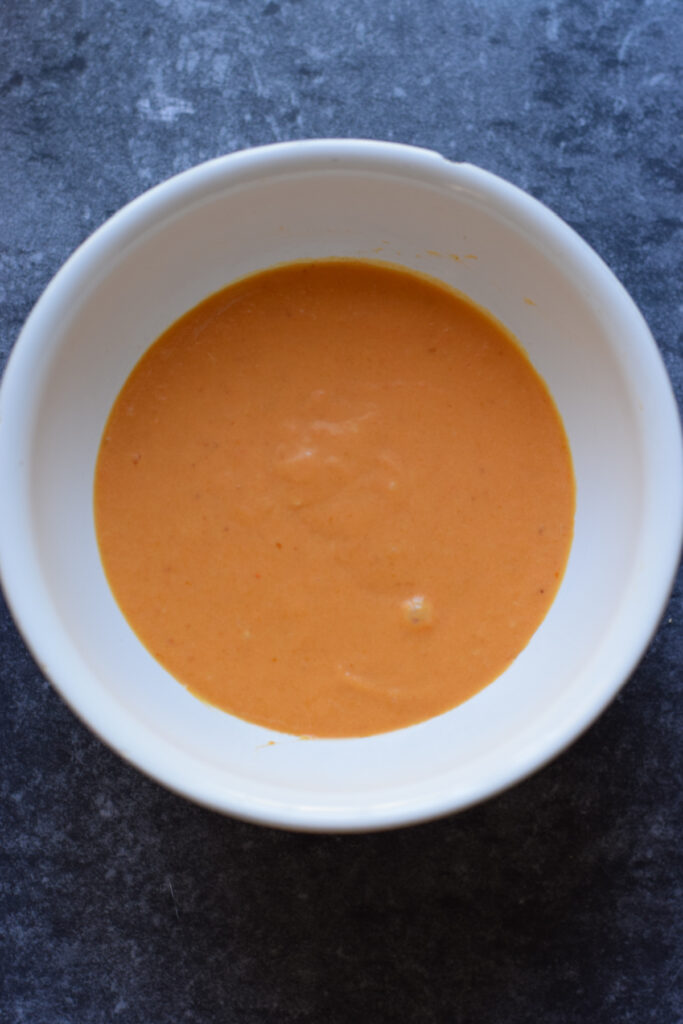 Whisked pumpkin puree in a white bowl.