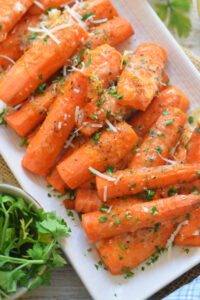 Roasted carrots with parmesan on a white plate.