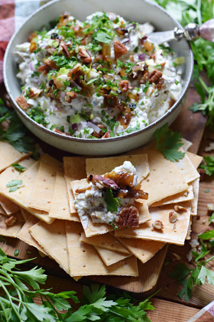 Dip in a bowl with pecans and caramelized onions.