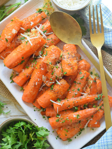 Roasted carrots on a white plate with parmesan cheese.