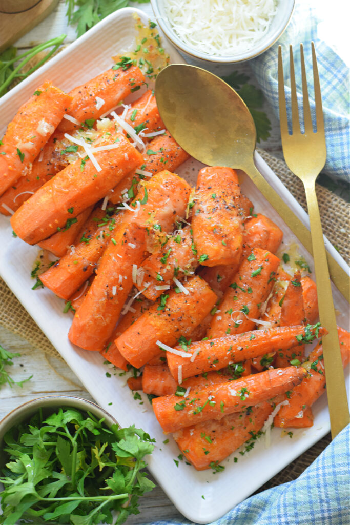 Roasted carrots on a white plate with parmesan cheese.