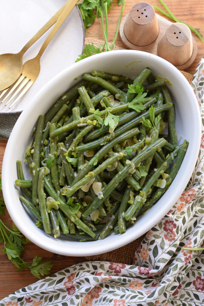 Sauteed green beans in a white serving dish.