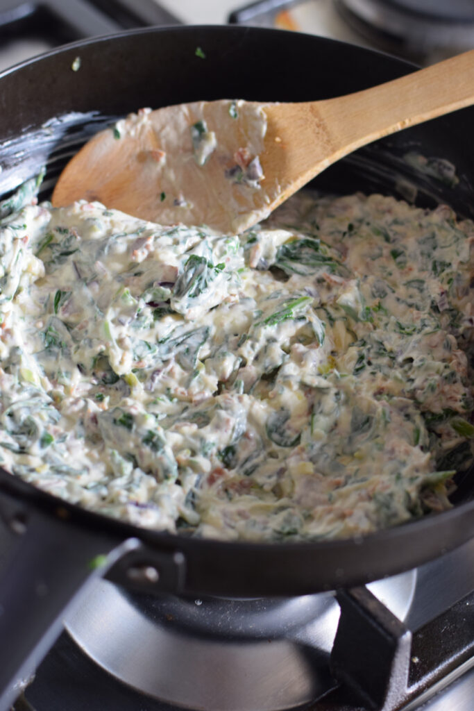 Creamy spinach filling in a skillet.
