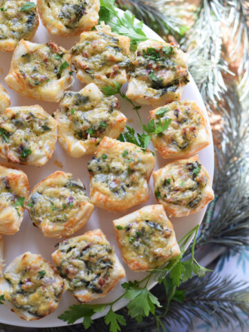 Spinach puffs on a white serving plate.