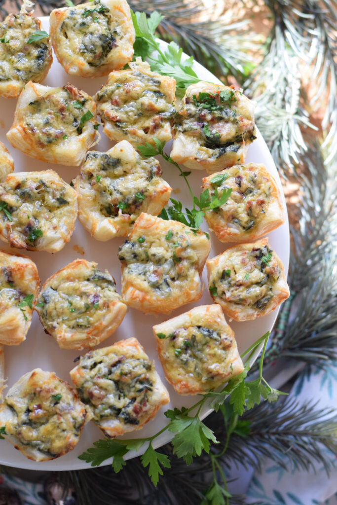 Spinach puffs on a white serving plate.