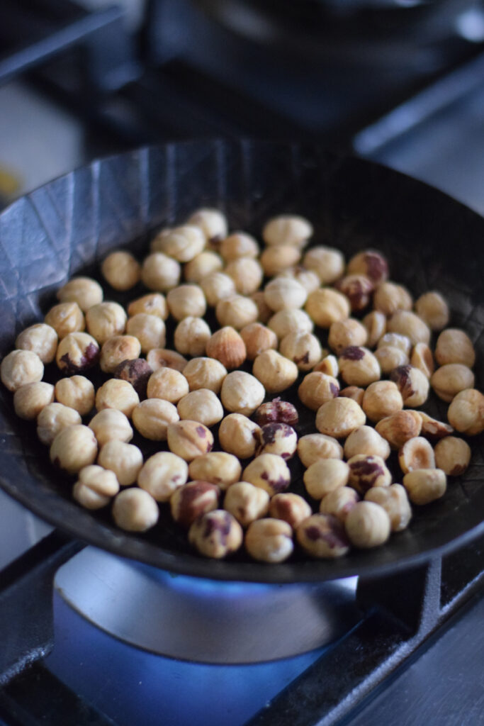 Toasting hazelnuts in a skillet.