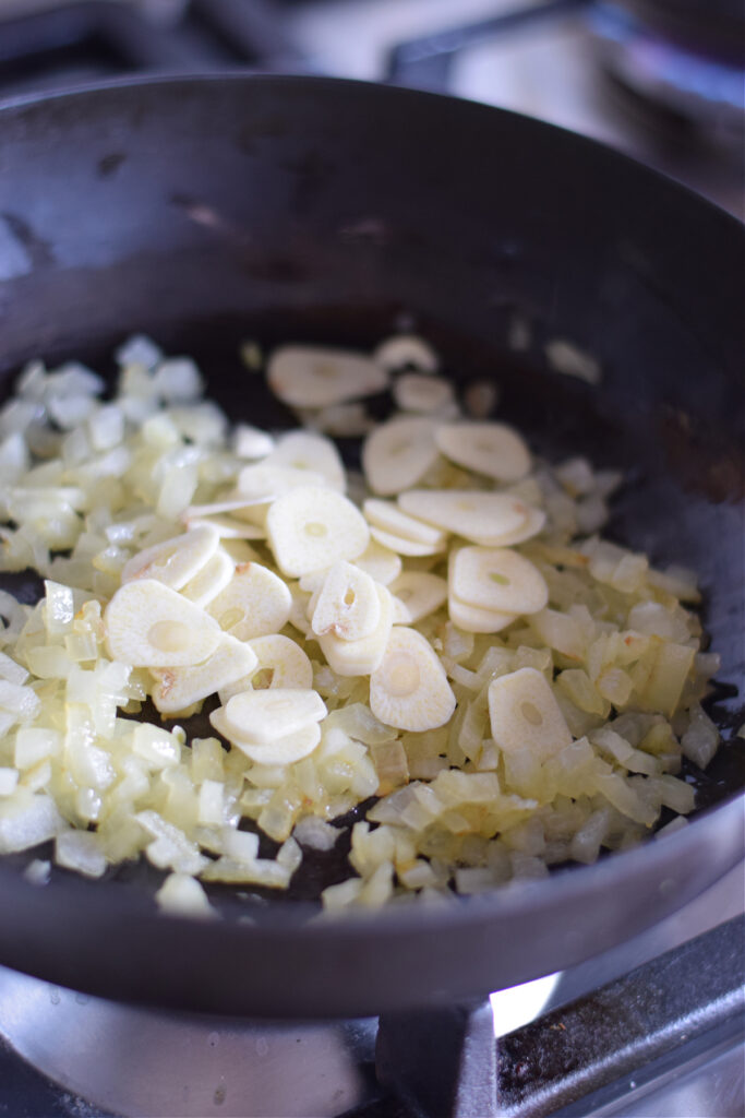 Garlic and onions in a black skillet.