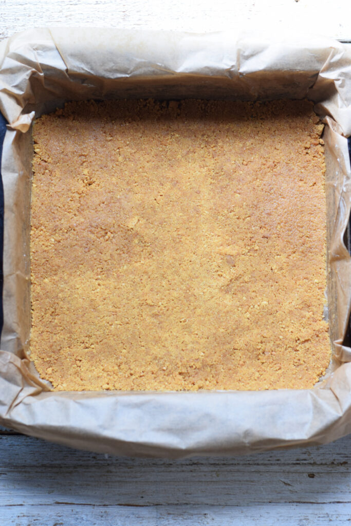 Cookie crumb base in a baking pan.
