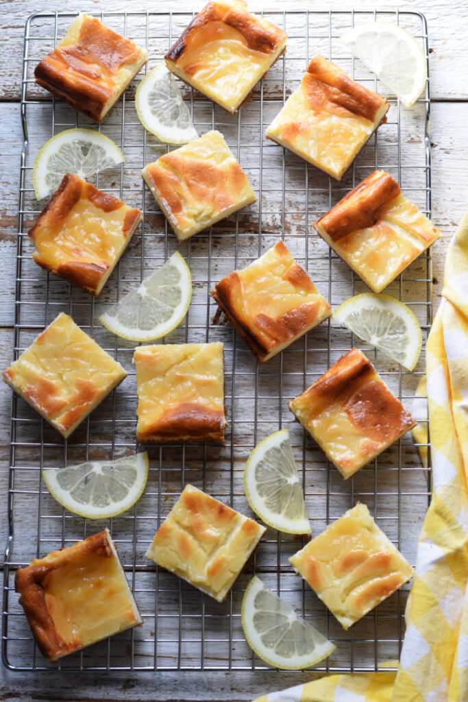 Lemon cheesecake bars on a baking rack.