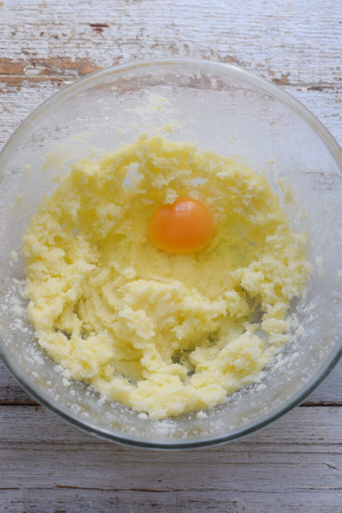Adding eggs to muffin batter in a bowl.