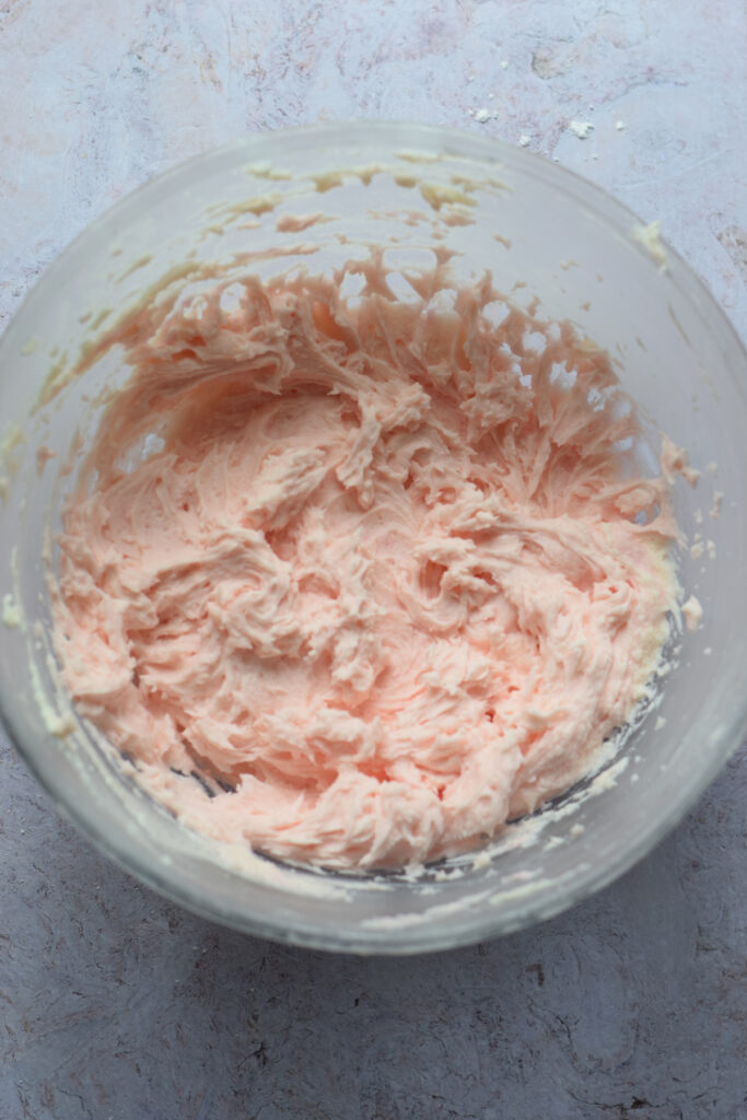 Pink frosting in a bowl.