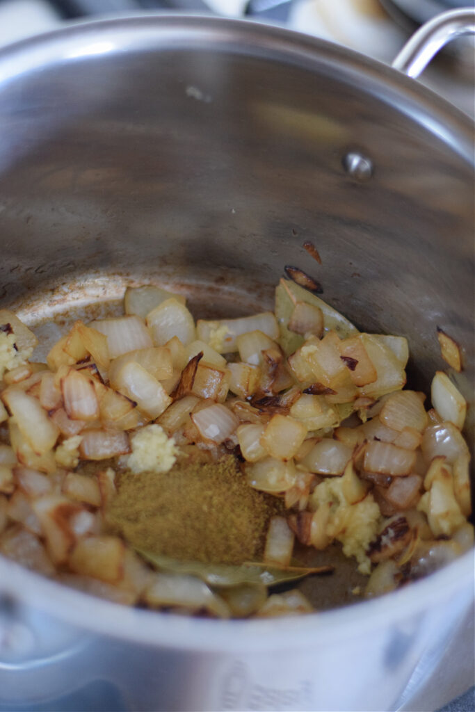 Adding spices to cooked onions.