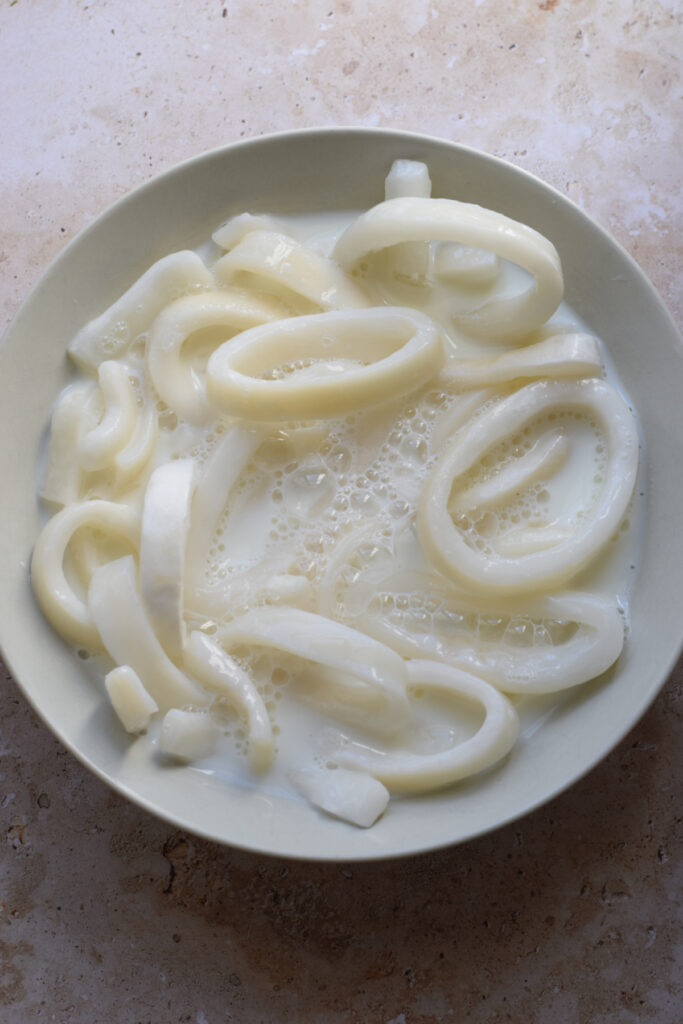 Soaking calamari rings in milk.