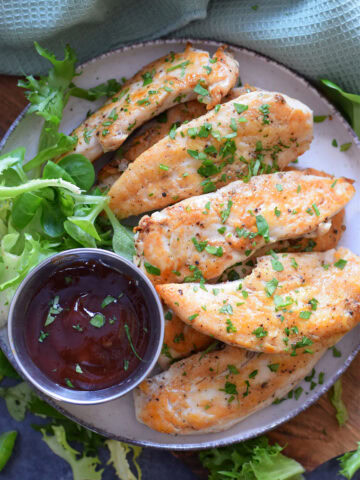 chicken tenders on a plate with dip.