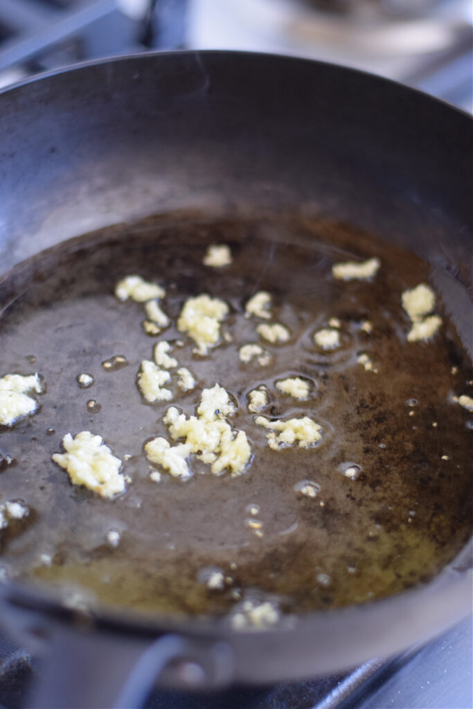 Cooking garlic in a skillet.
