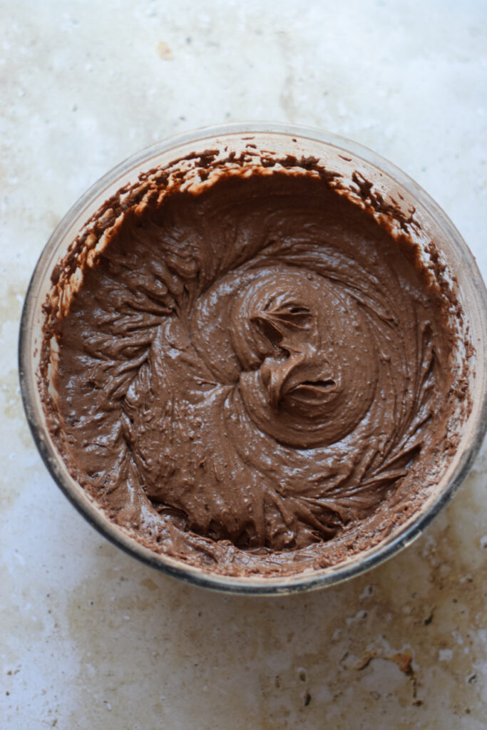 Chocolate muffin batter in a glass bowl.